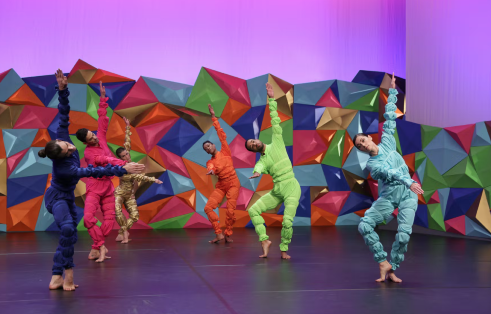 6 dancers performing on a colorful, geometric stage
