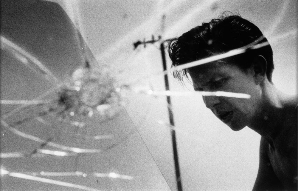 Photo of a  man, as seen through a cracked windshield