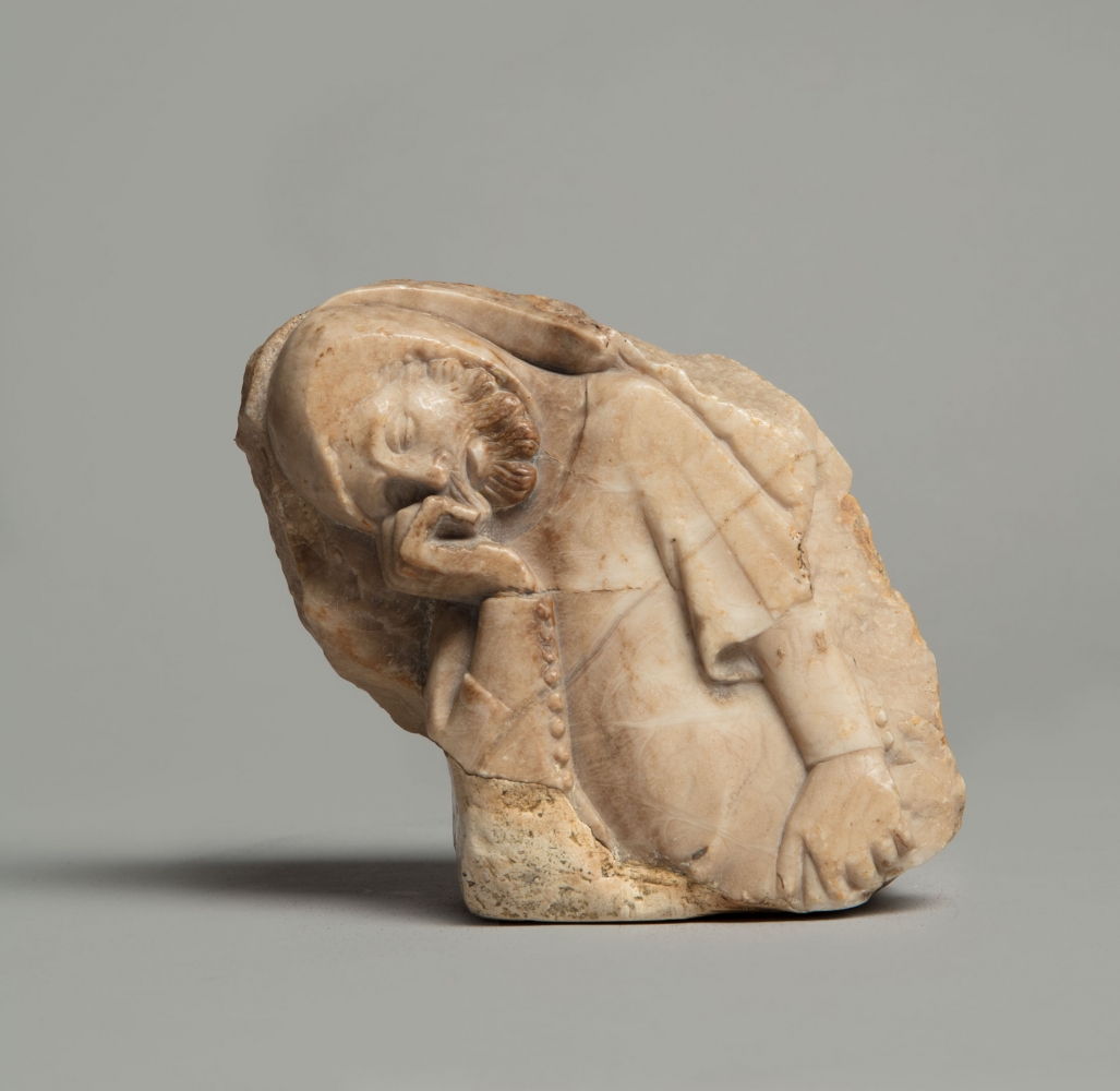 Jaume Cascalls
A mourner, most likely from the royal pantheon at Poblet, c. 1365-1380
Catalonia, Barcelona
Veined alabaster with traces of a calcite ground layer and ochre polychromy; a fragment from a larger relief
5 5/8 x 5 x 2 inches
(14.3 x 12.7 x 5.1 cm)