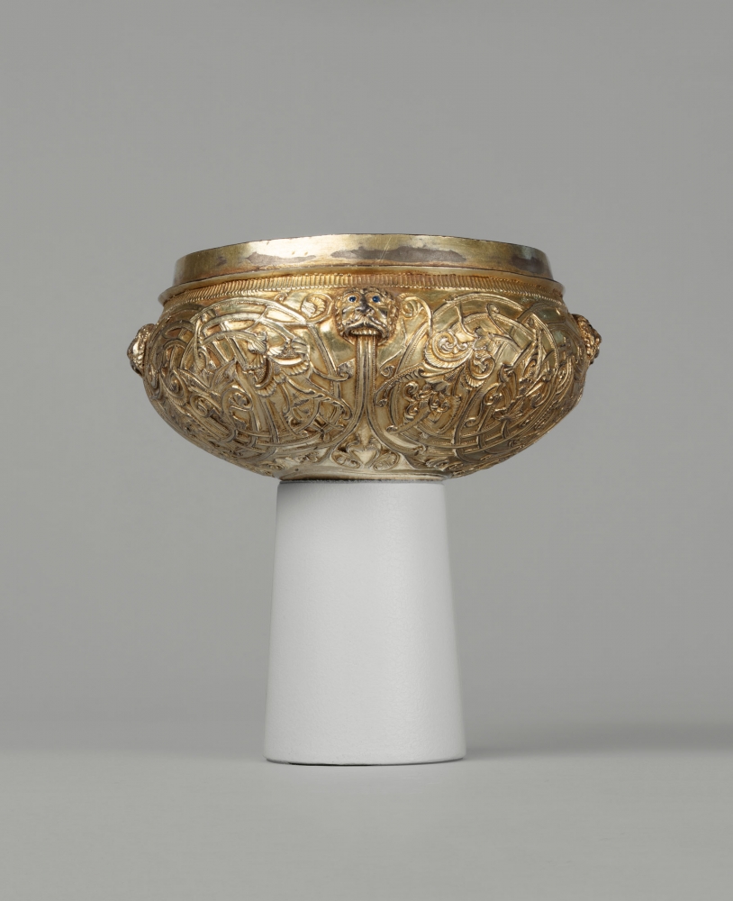 A cup with lions&amp;rsquo; heads emitting flowering rinceaux, c. 1180
England
Cast, chased, gilded and tooled silver with inlaid blue glass eyes
2 1/2 x 5 7/8 x 5 7/8 inches
(6.3 x 15 x 15 cm)