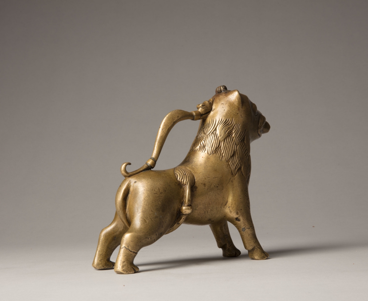 An aquamanile in the form of a lion, Early 13th century
Germany, probably Lower Saxony
cast copper alloy with fine soldered repairs to the handle at its upper and lower connecting points. Hairline fractures to the legs in two places. The hinged lid a modern replacement.
6 3/4 x 9 1/8 x 2 1/8 inches
(17.1 x 22.9 x 5.5 cm)