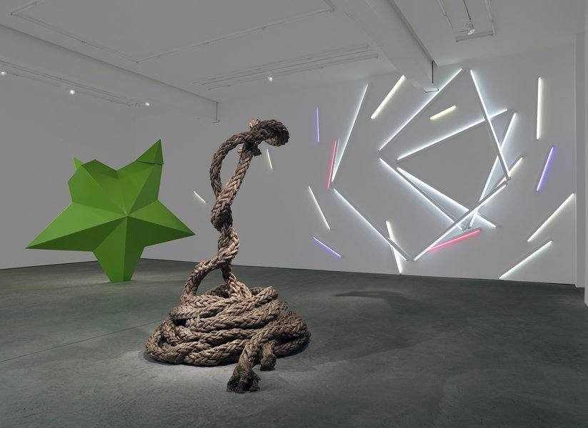 Art gallery installation of an exhibition, with 2 sculptures and a neon light piece