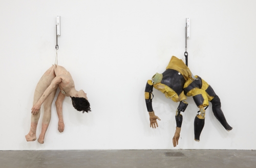 2 sculptures of human bodies on wall