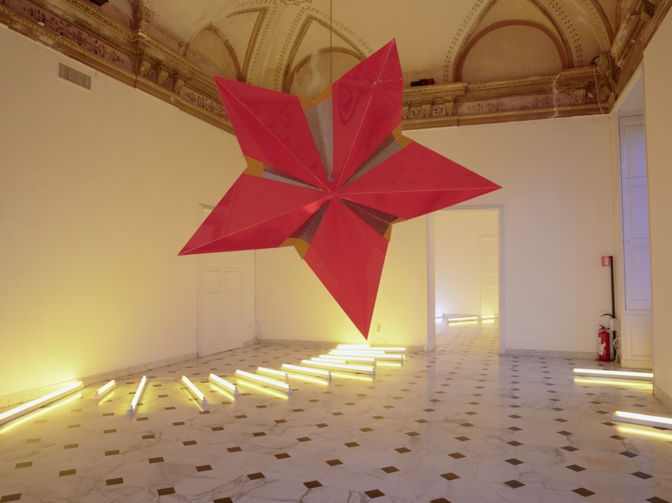 Art gallery installation of an exhibition, with a star sculpture and  neon light piece